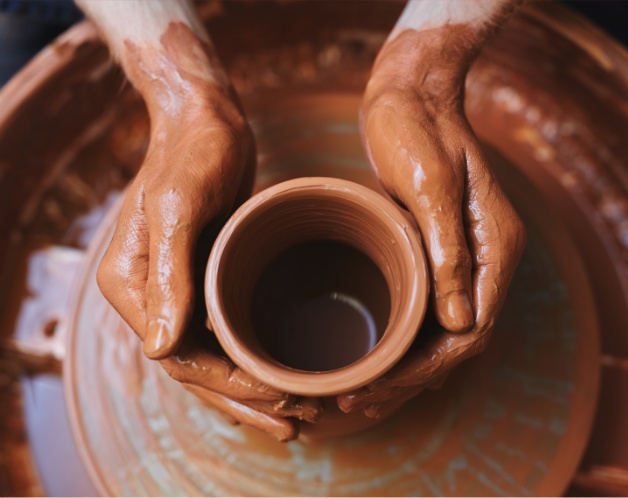 Hands shaping a clay pot